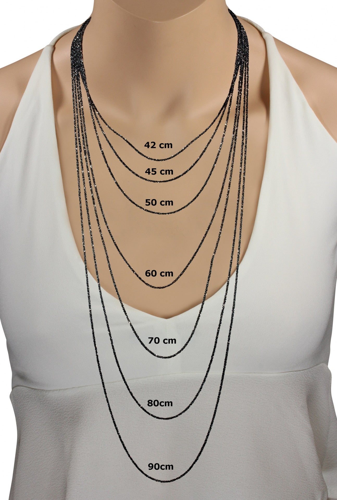 Längenvergleich von sieben geschwärzten Criss-Cross-Ketten aus Silber für Damen an einer Schaufensterpuppe in den Kettenlängen von 42 cm bis 90 cm.