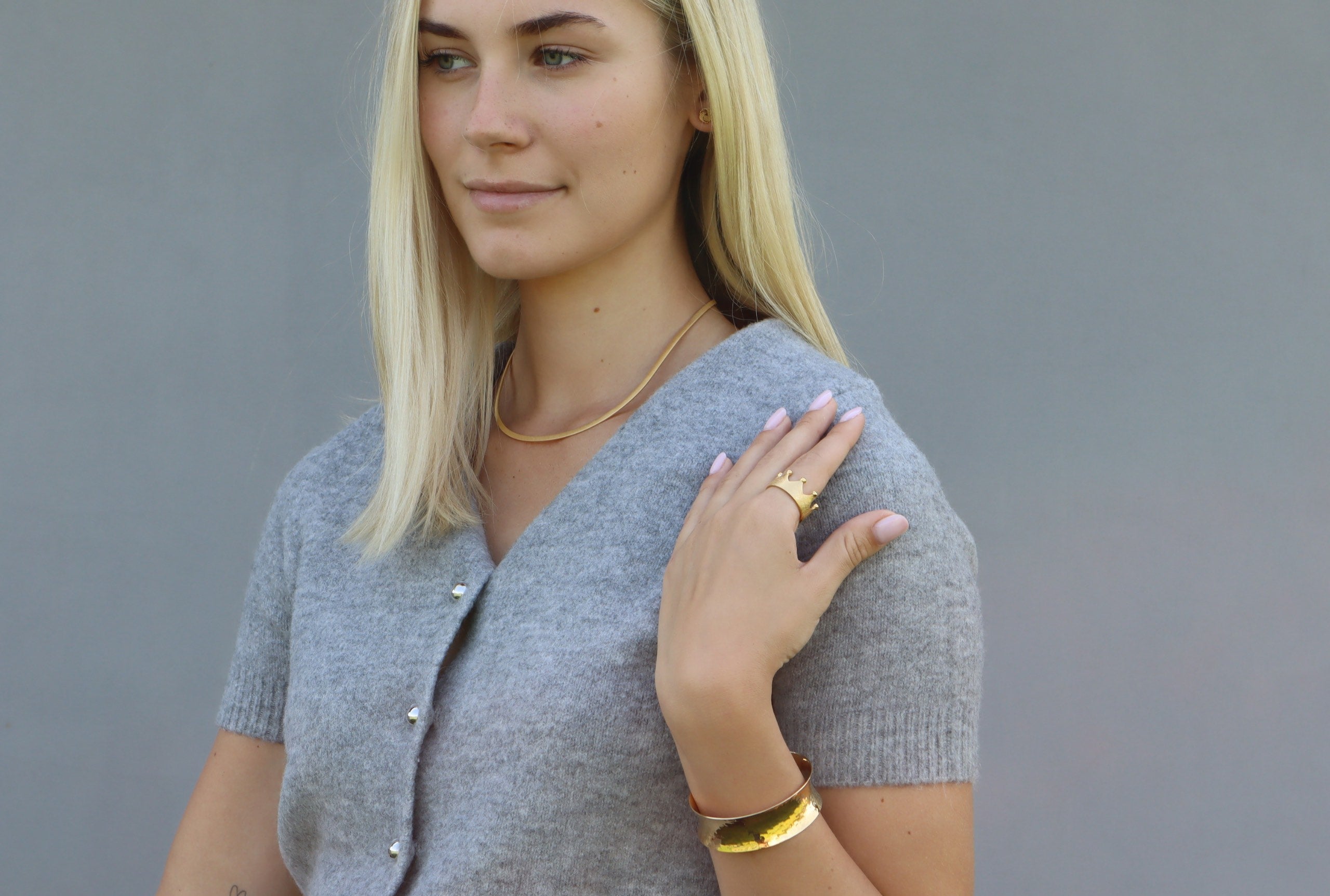 Ein klassicher Halsreif für Damen, von Hand geschmiedet aus Silber und mit Gold plattiert, getragen am Hals einer Dame.