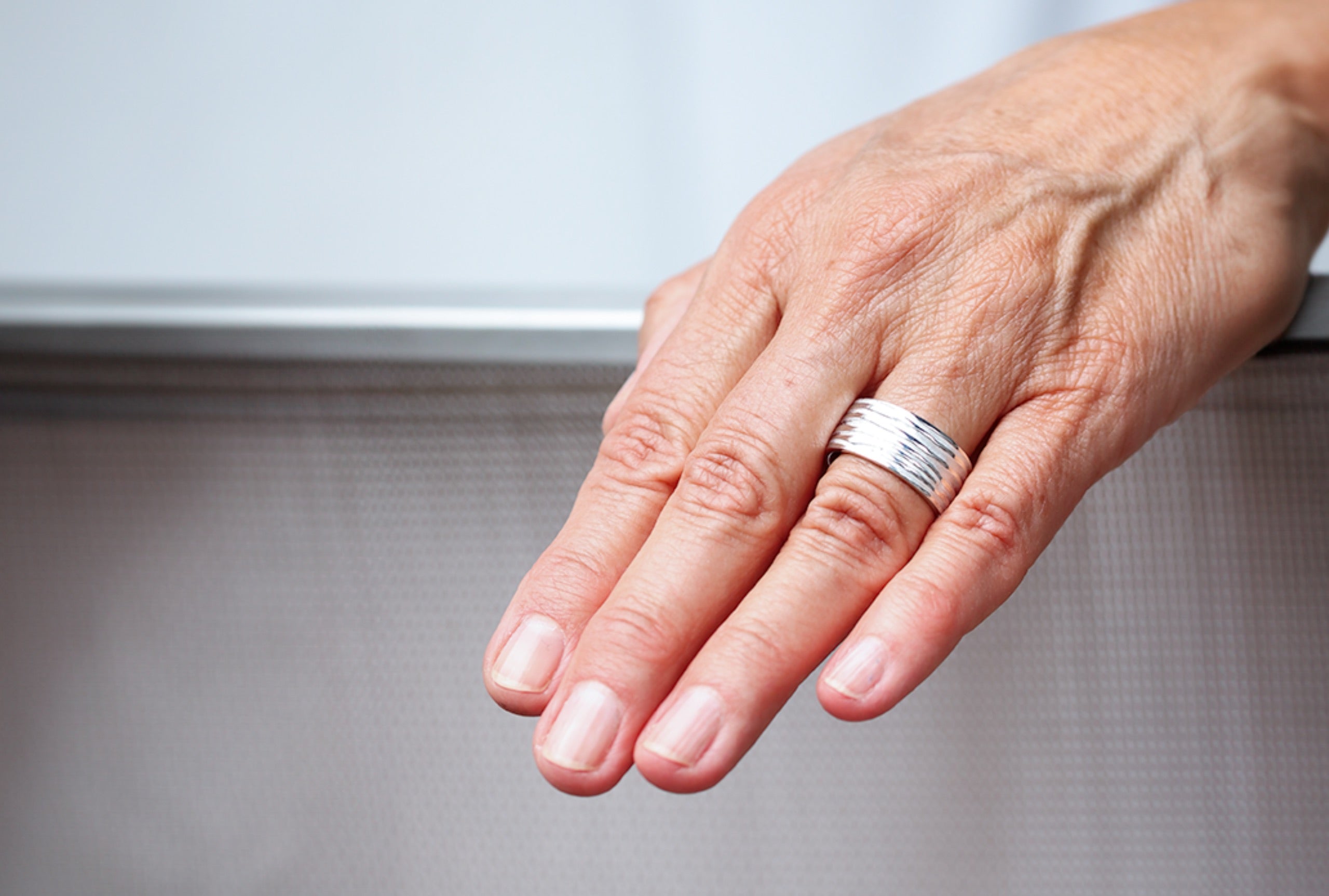 Ein breiter Silberring in großen Größen mit einer gefalteten Wellenstruktur. Der Ring bietet sich als Damenring und als Herrenring an.