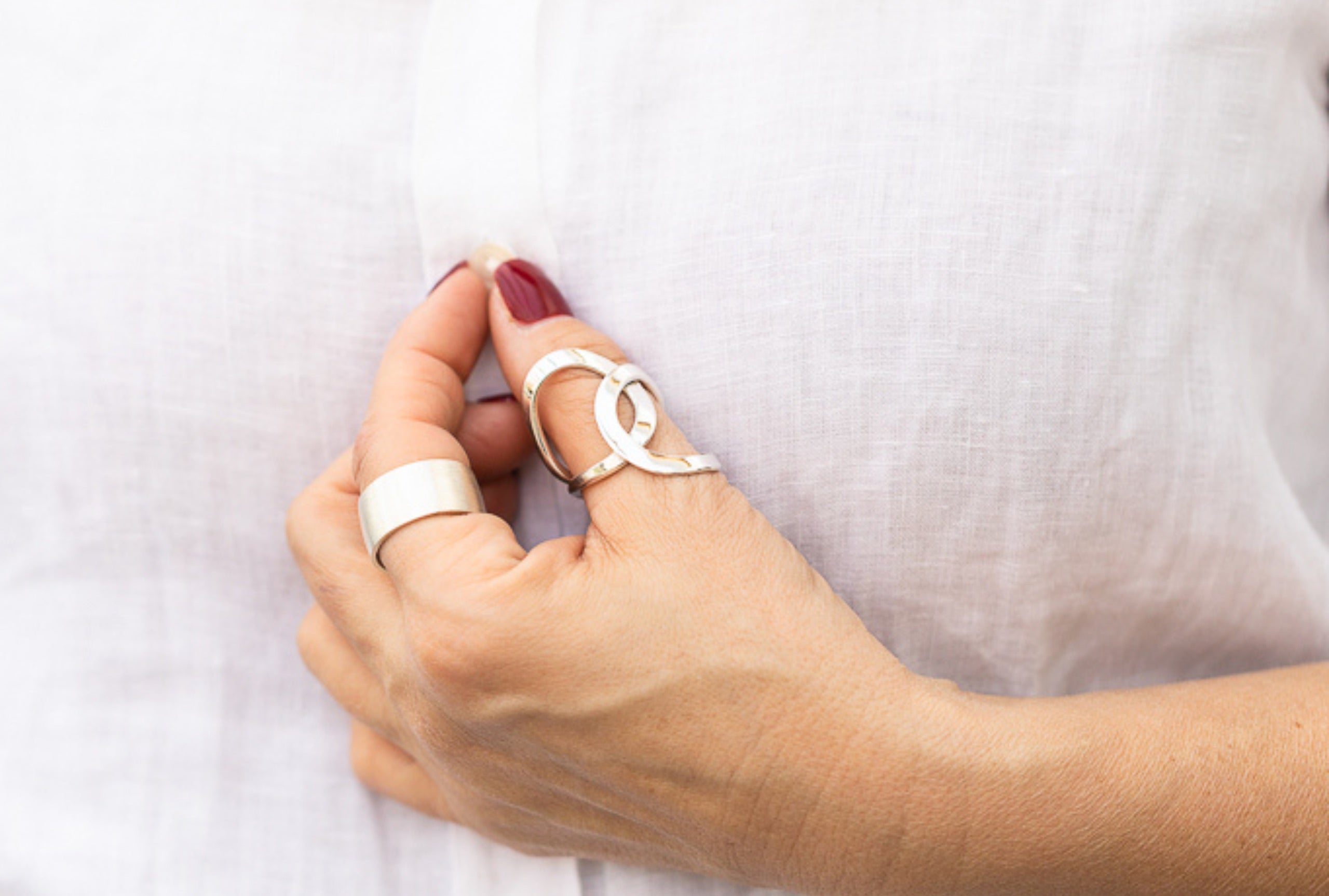 Geschmiedeter Damenring in den Größen 64 bis 70 bestehend aus zwei Kreisen, die kunstvoll ineinander verschlungen sind, getragen am Daumen einer Damenhand.