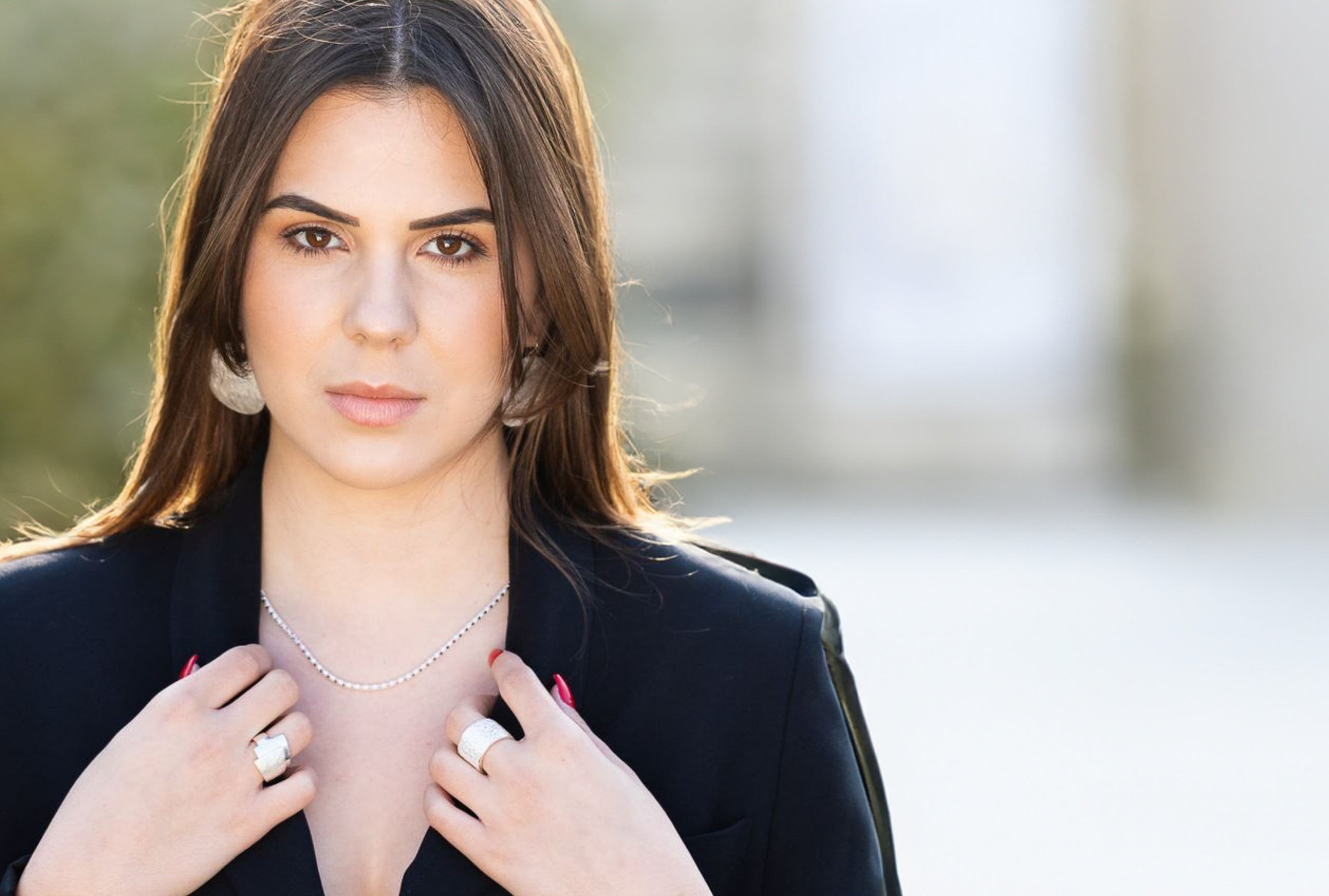 Ein breiter Damenring aus Silber mit einer gehämmerten Struktur-Oberfläche, getragen an einer Damenhand.