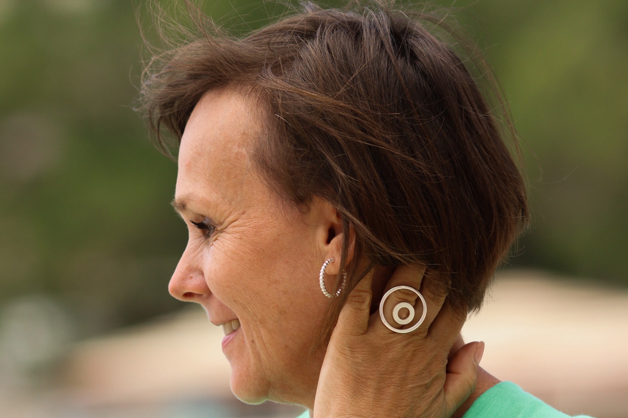 Ein Paar offen gearbeitete kleine Creolen aus Silber im Kugel Design für Damen.