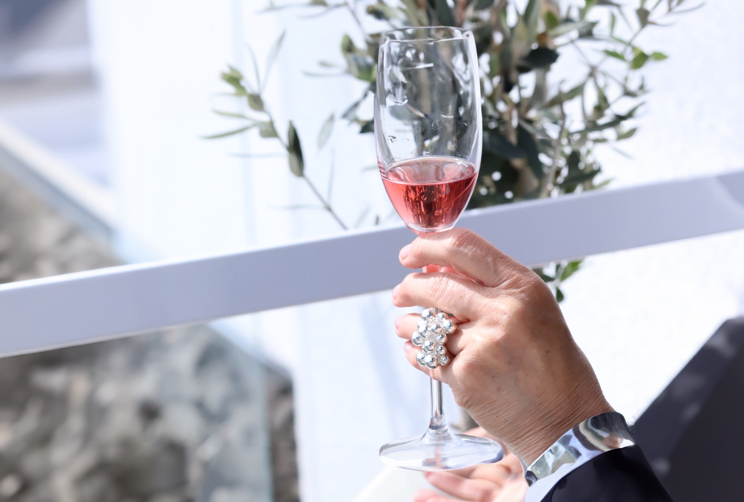 Ein opulenter Designring mit großen dekorativen Kugeln aus Silber, getragen an einer Damenhand.