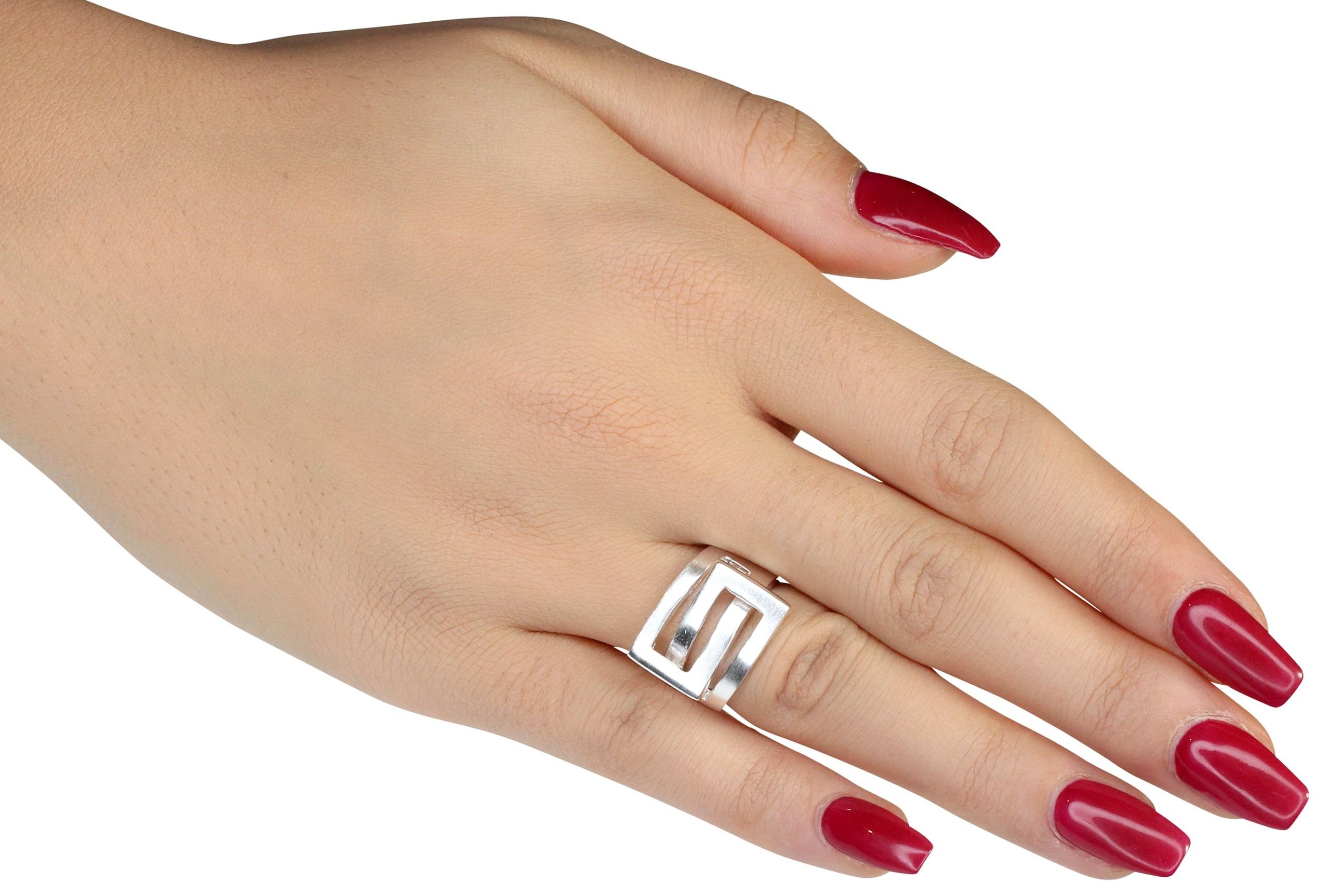 Ein Ring aus Silber für Damen, bestehend aus einer massiven Ringschiene und zwei ineinander greifenden Vierecken, getragen an einer Damenhand.