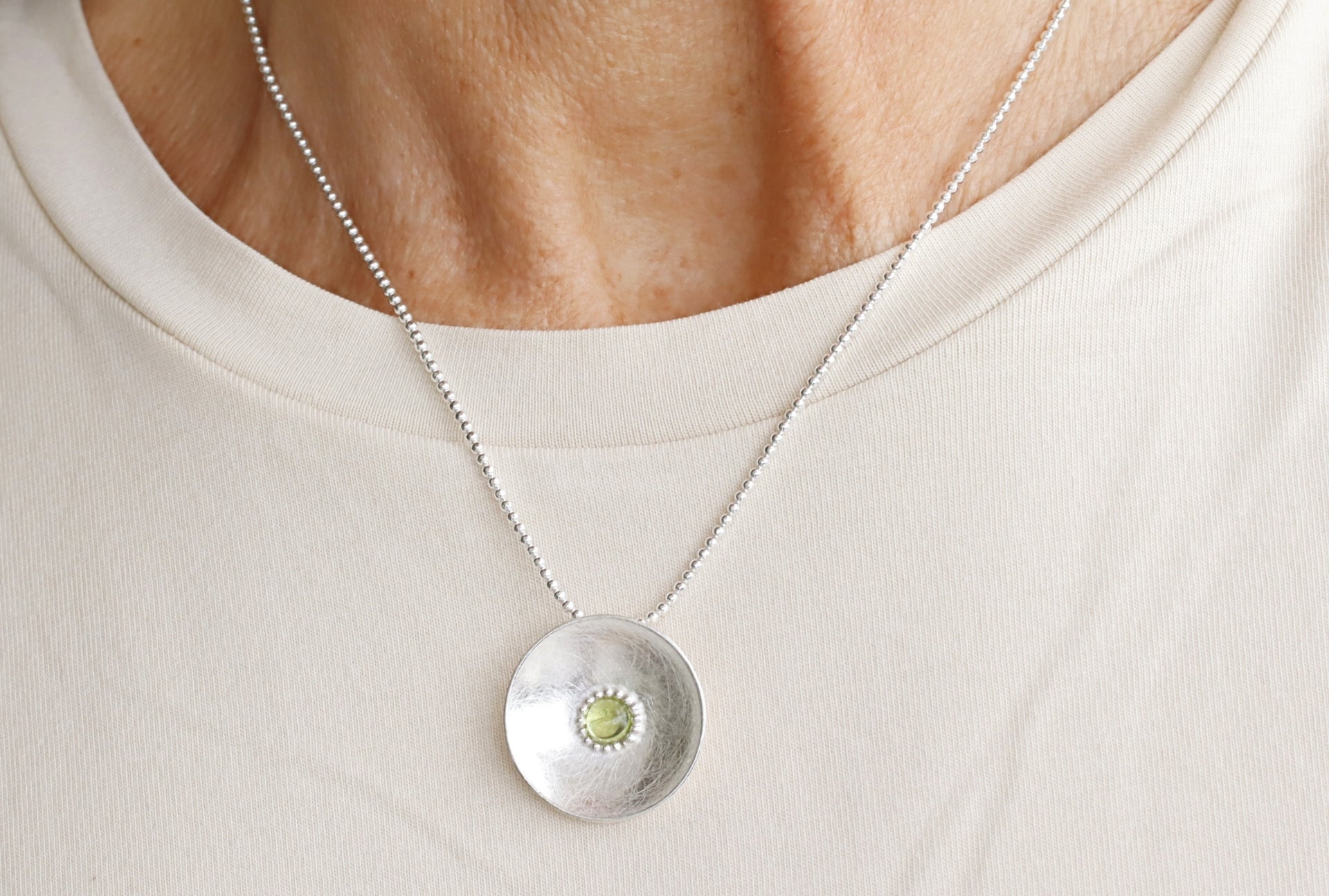 Gebürsteter Schalenanhänger mit gefasstem Peridot