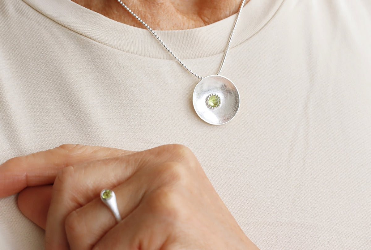 Gebürsteter Schalenanhänger mit gefasstem Peridot