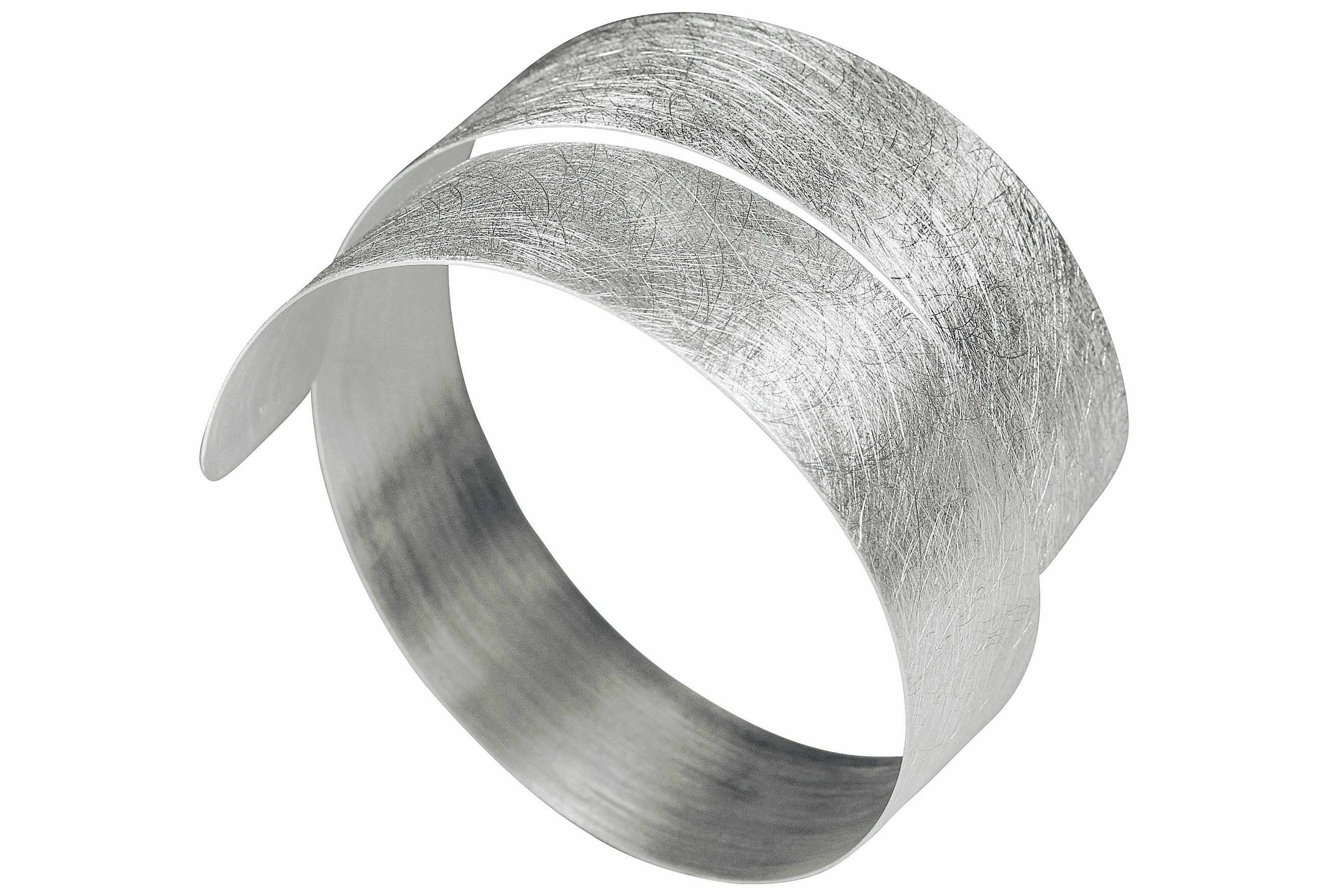 Silberner Armreif mit gebürsteter Oberfläche. Der Armreif ist schmal und spiralförmig.