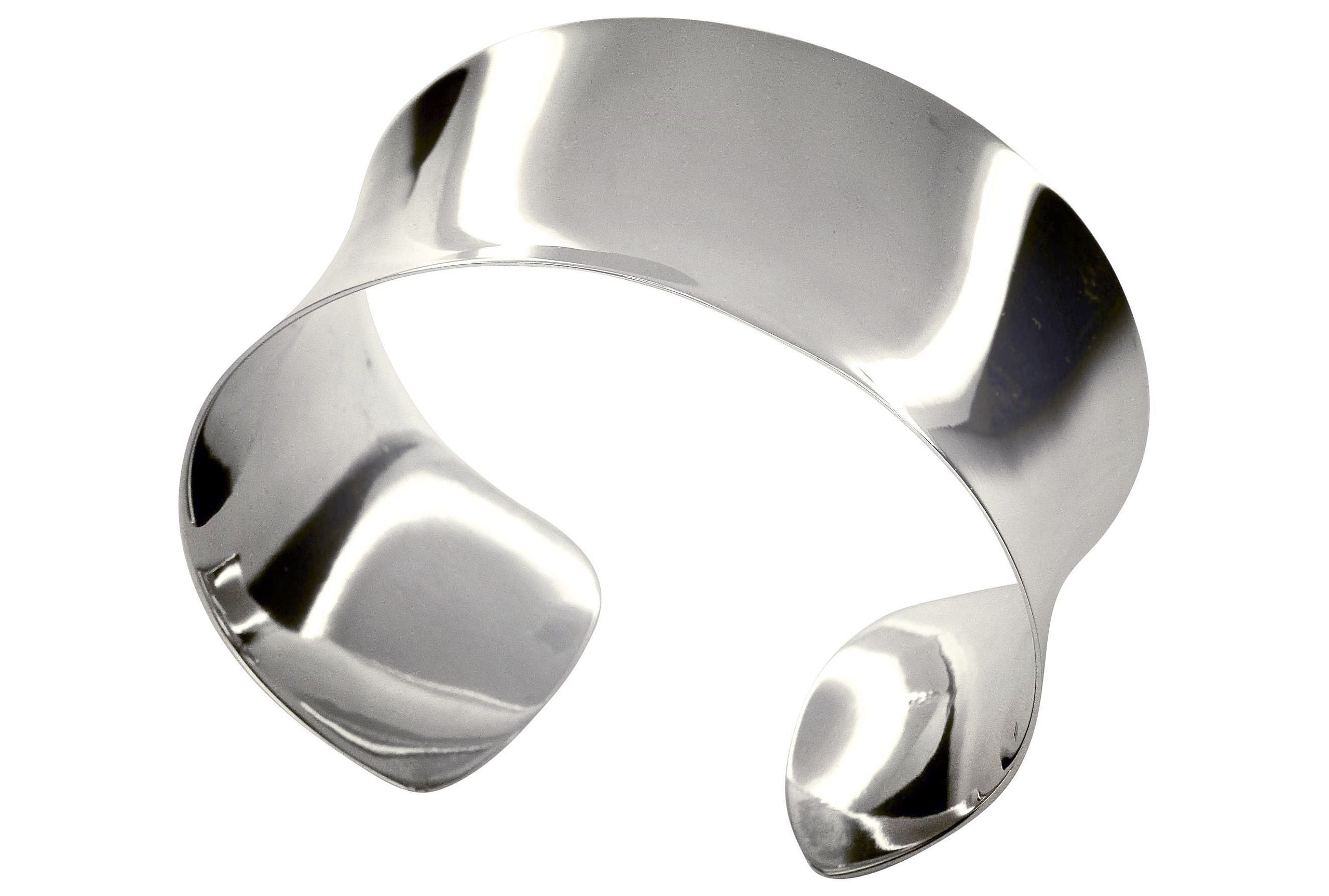 Ein klassischer Armreif aus Silber für Damen, der eine glänzend polierte Oberfläche aufweist.