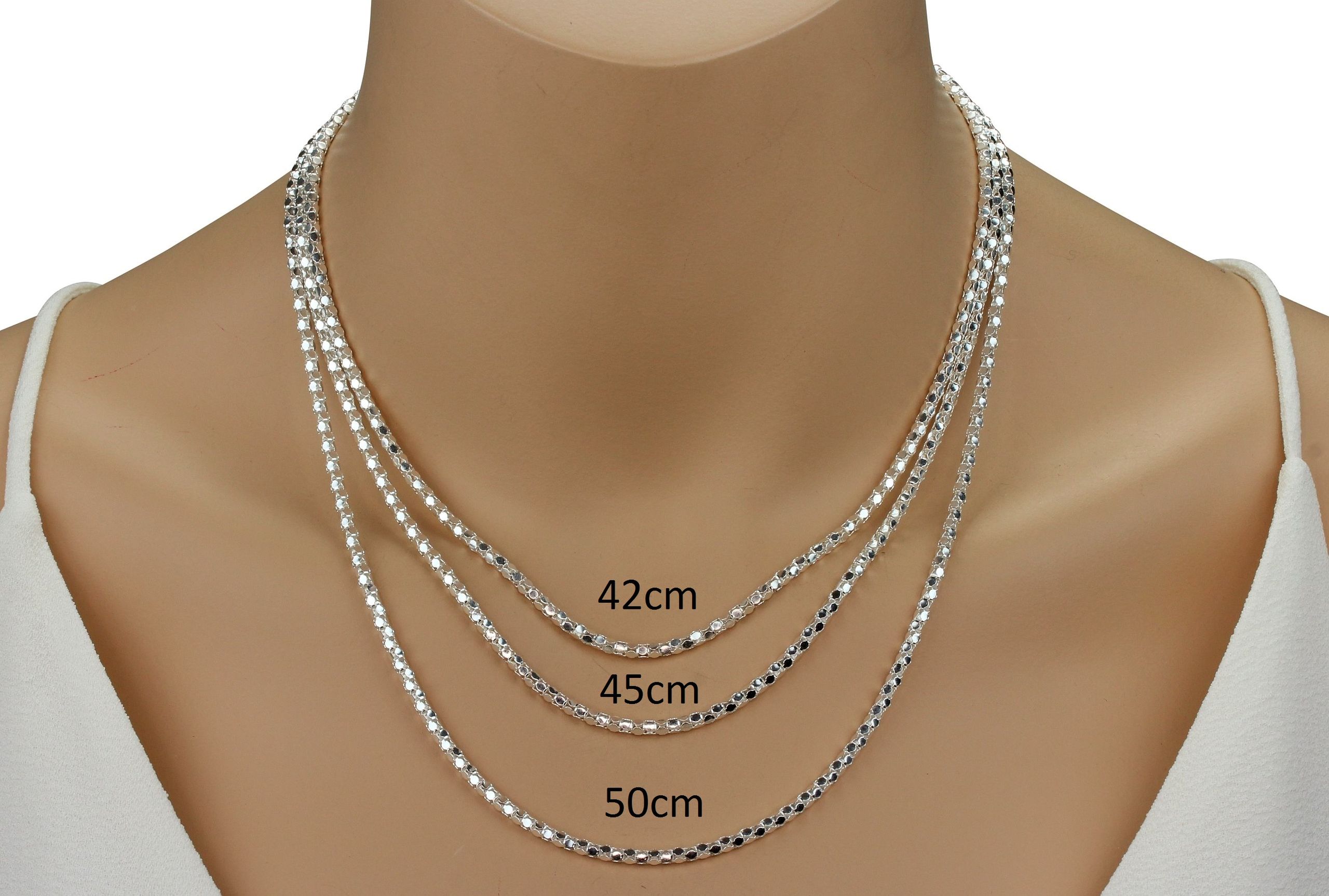 Eine Popcornkette aus Silber für Damen mit einem eleganten Geflecht, getragen an einer Schaufensterpuppe.