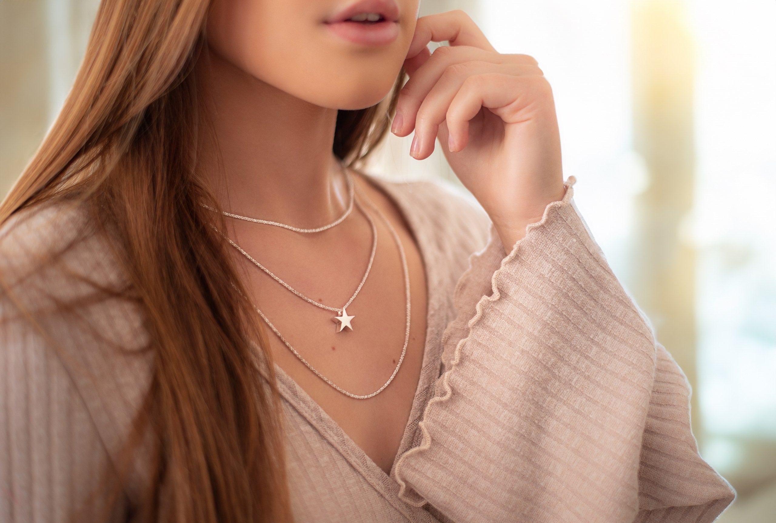 Criss-Cross-Kette aus Silber für Damen mit einem geschmeidigen Geflecht und einer glänzend funkelnden Oberfläche, getragen am Hals einer Dame.