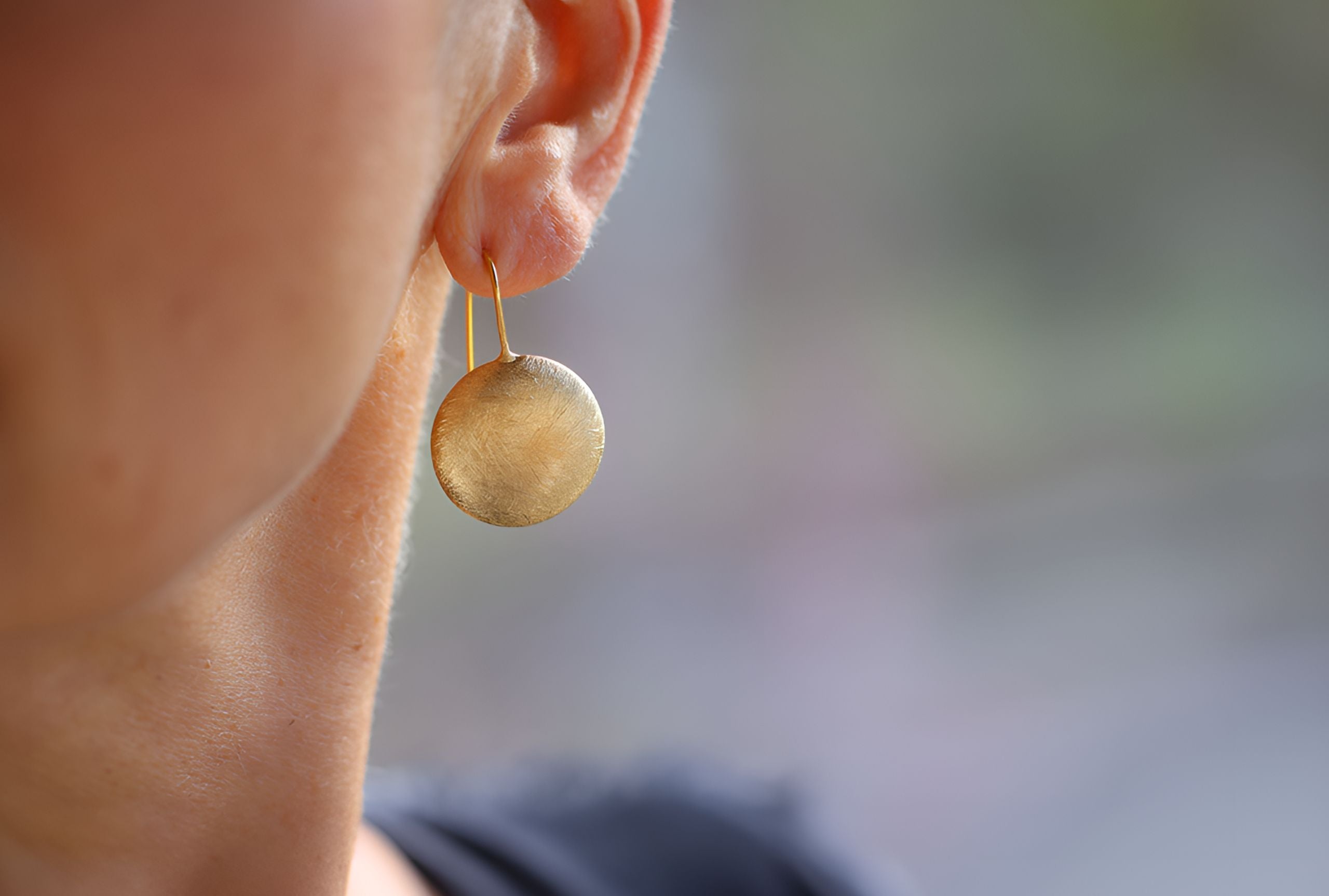 Große runde Ohrhänger aus vergoldetem Silber für Damen in Form eines Knopfs, die eine mattierte Oberfläche aufweisen.