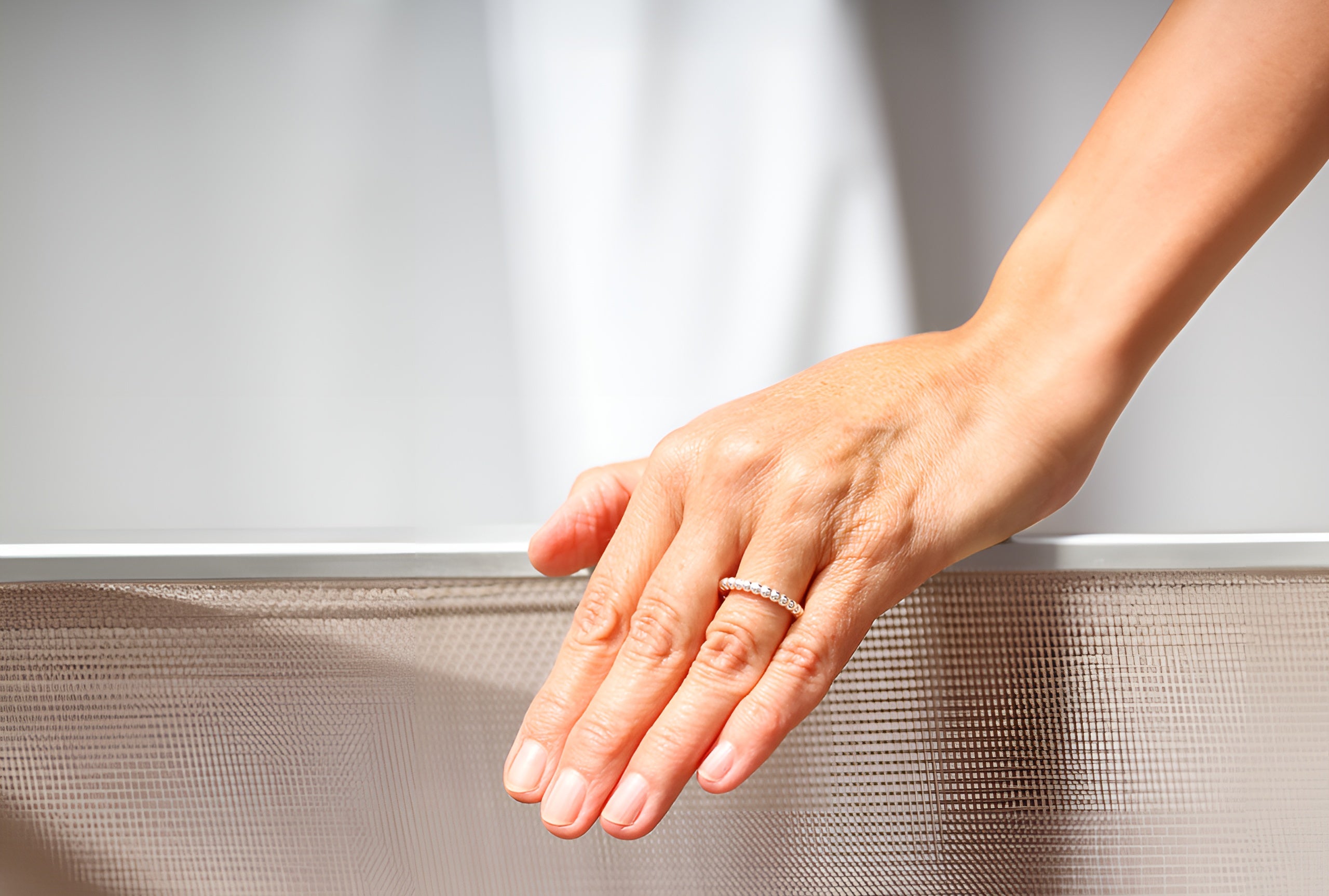 Ein kleiner Kugelring aus Silber für Damen. Der Ring wird hier als Beisteckring an einer Damenhand getragen.