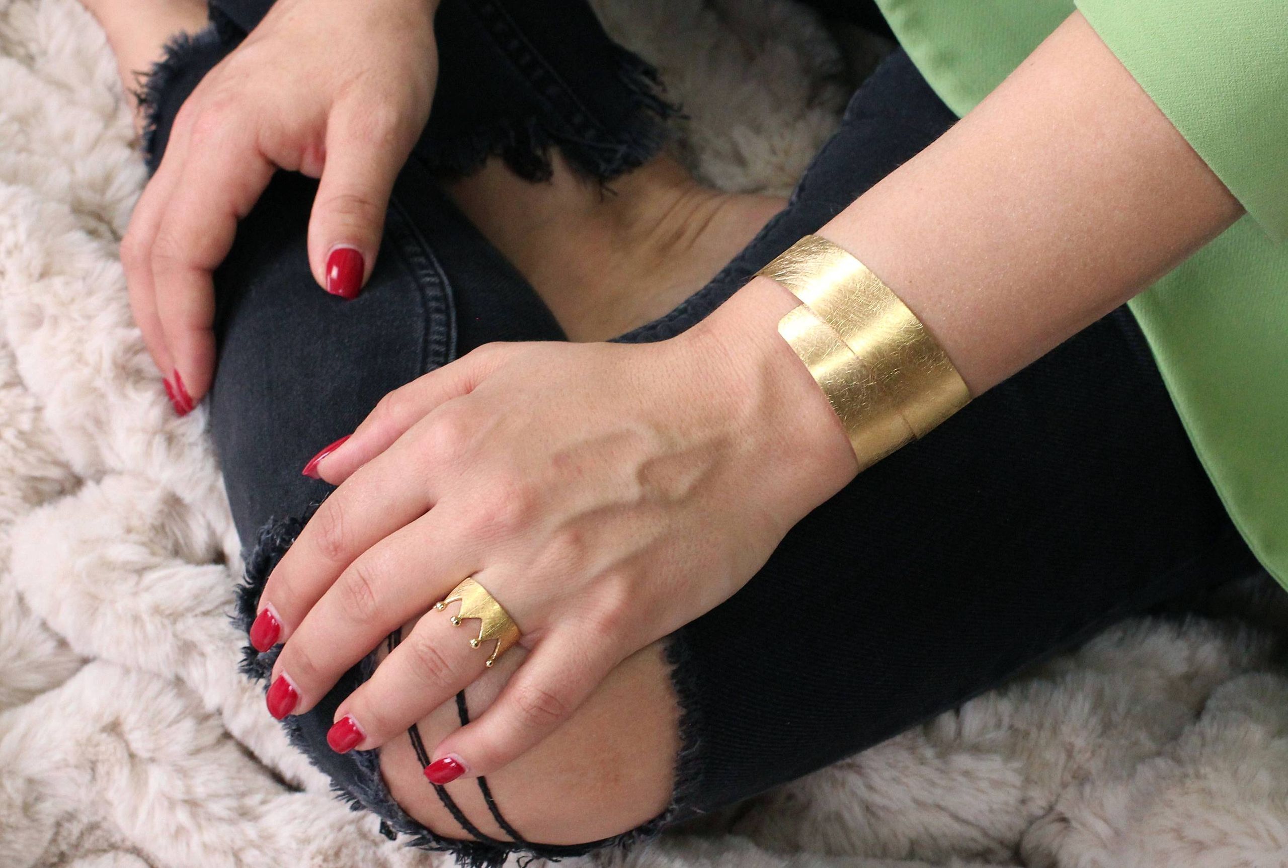 Armreif aus Silber mit vergoldeter Oberfläche getragen am Handgelenk einer Dame. Der Armreif ist spiralförmig und flexibel.