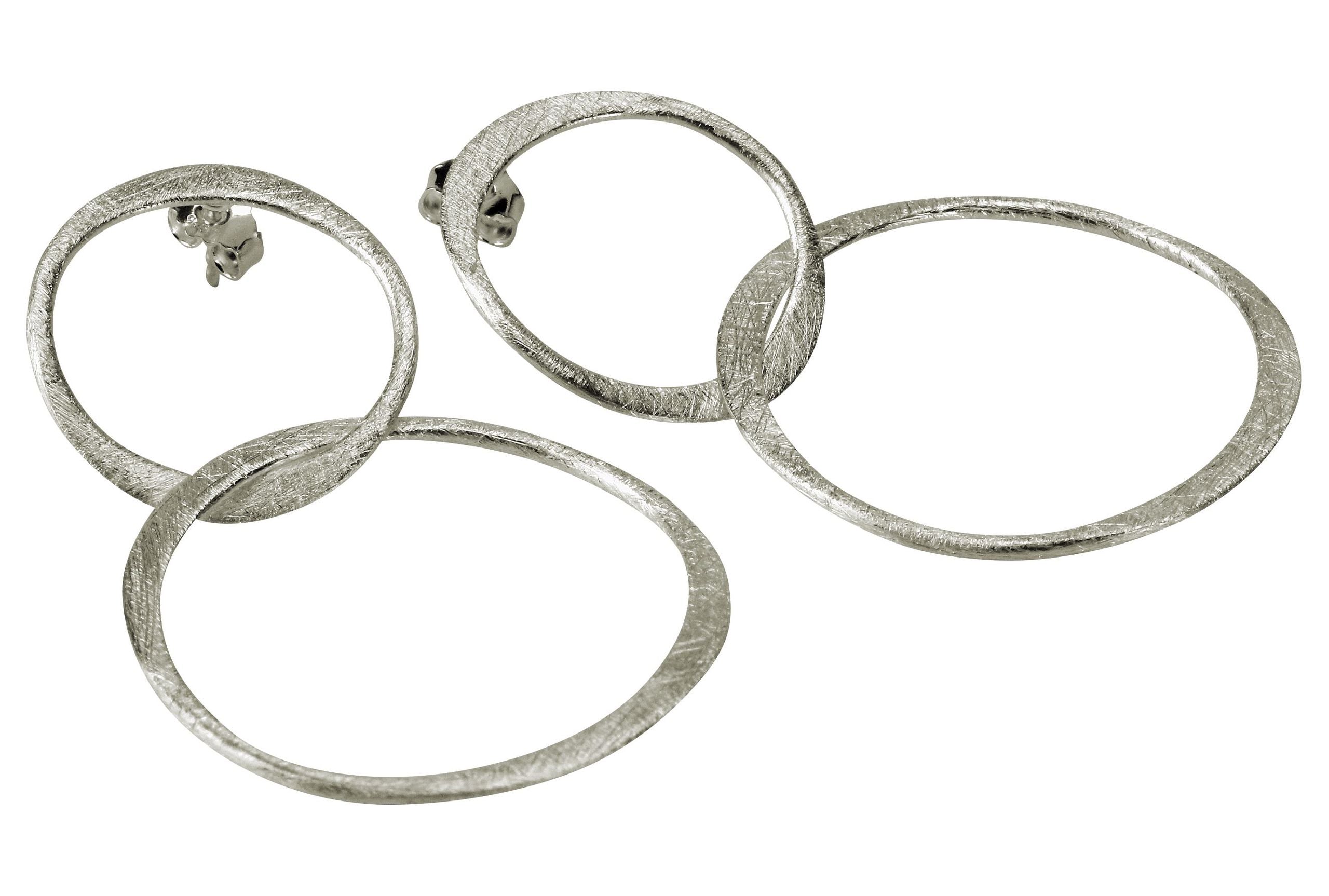 Große geschmiedete Ohrhänger aus Silber in Form zweier verbundener Kreise.
