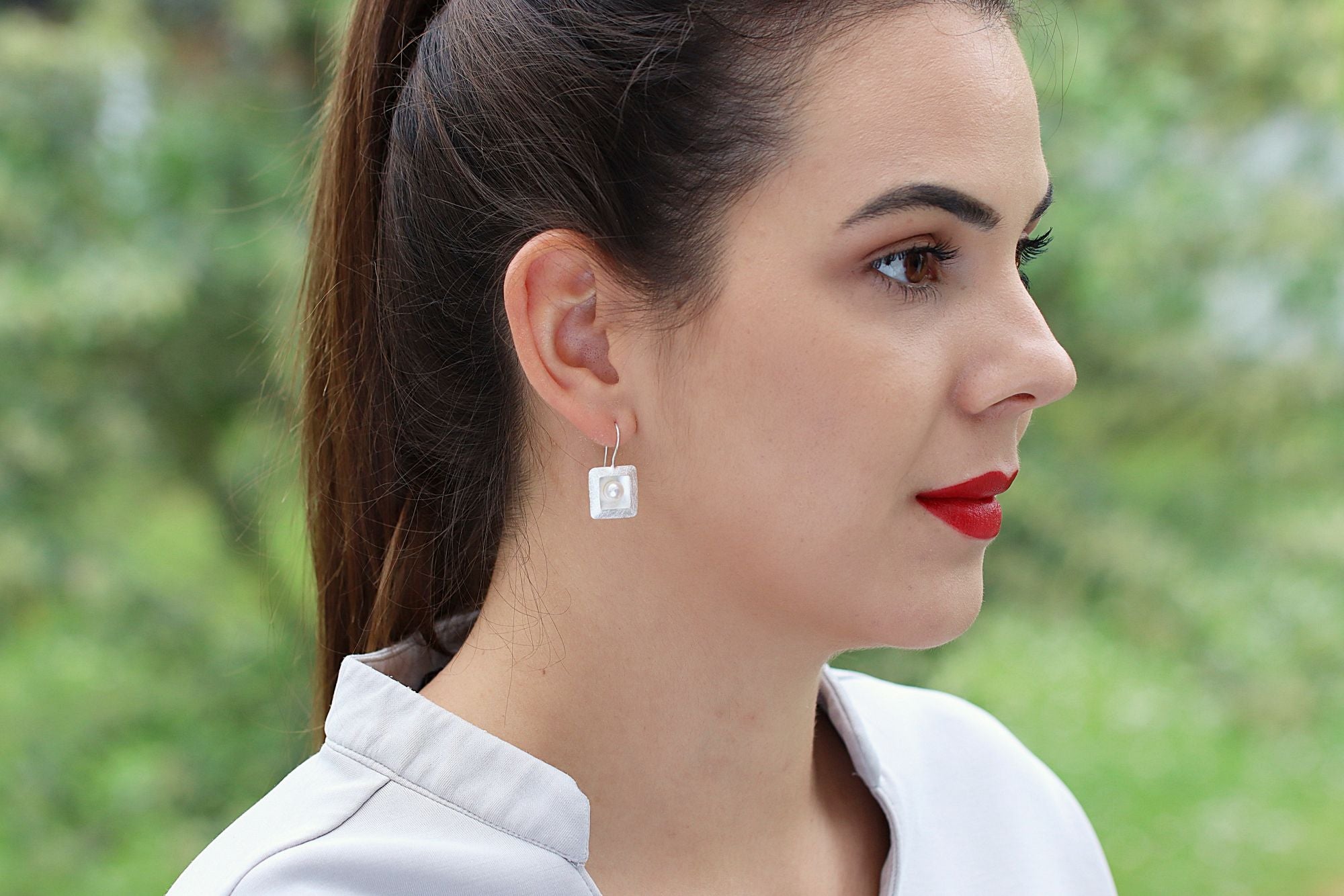 Ohrhänger aus Silber für Damen mit einem quadratischen Zierelement, in denen mittig jeweils eine Perle sitzt.