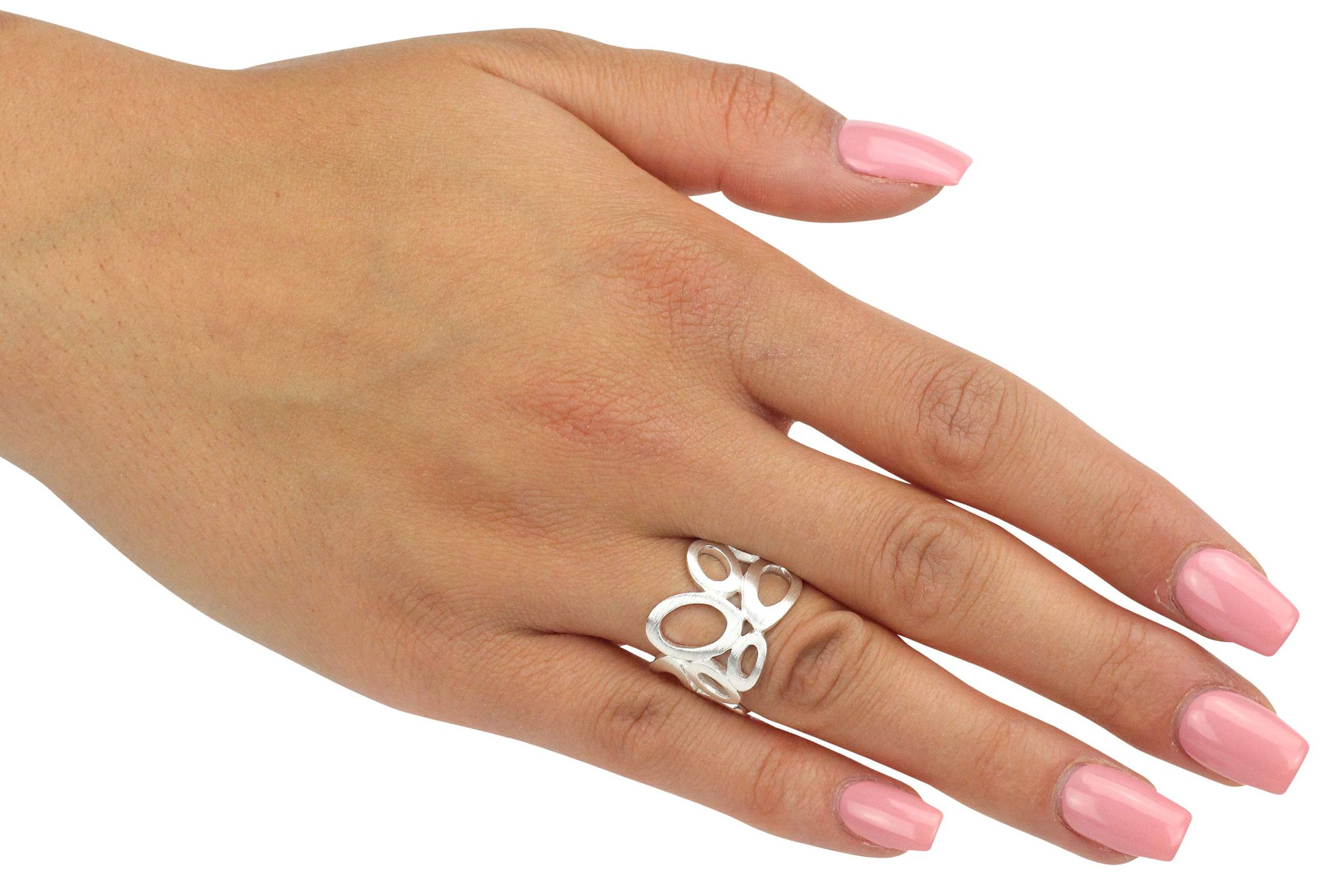 Ein Motivring aus Silber im Design offen gearbeiteter Kreise, getragen an einer Damenhand.