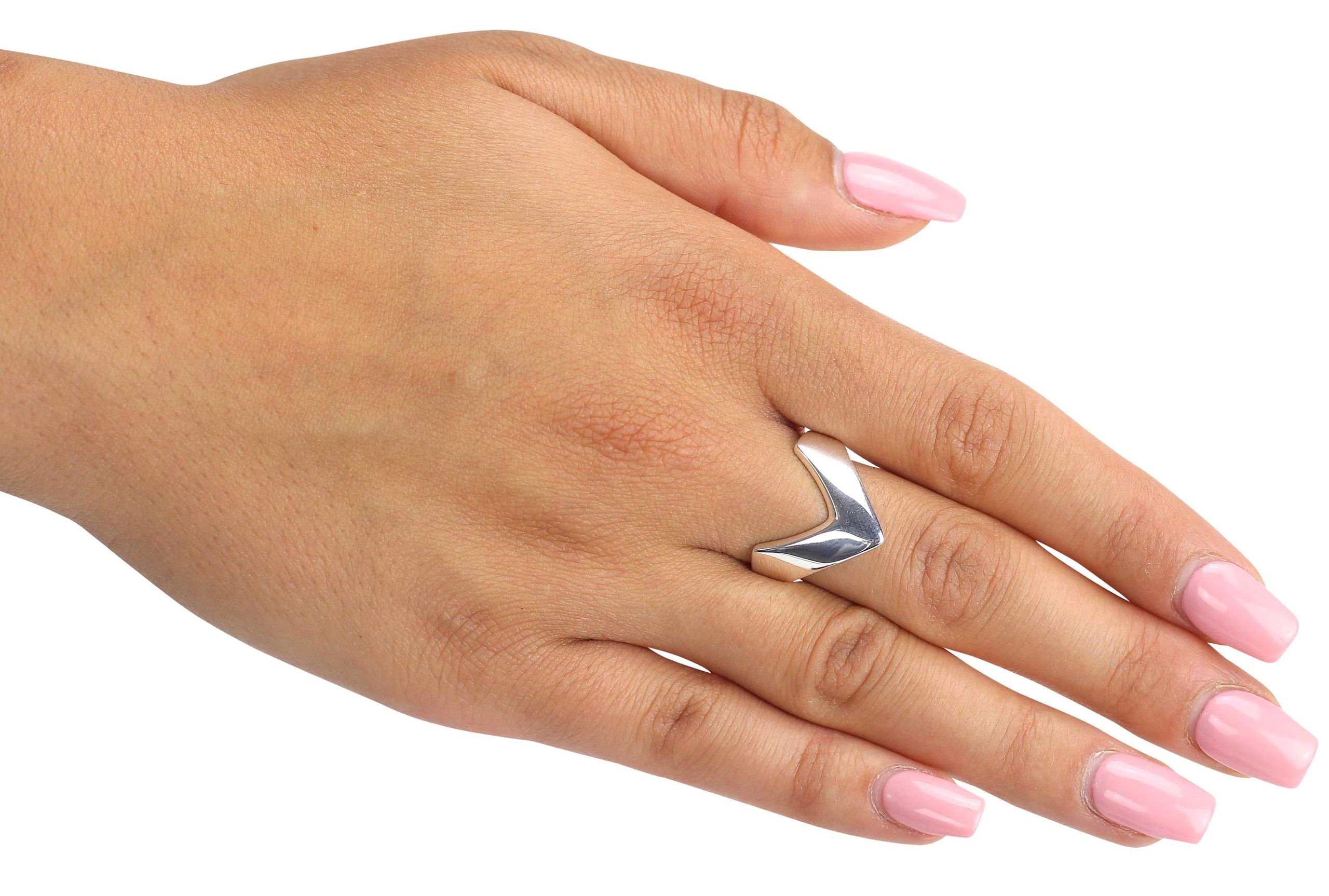 Ein spitz zulaufender Bandring aus Silber, der am Finger wie ein kleiner Pfeil nach vorne zeigt, getragen an einer Damenhand.