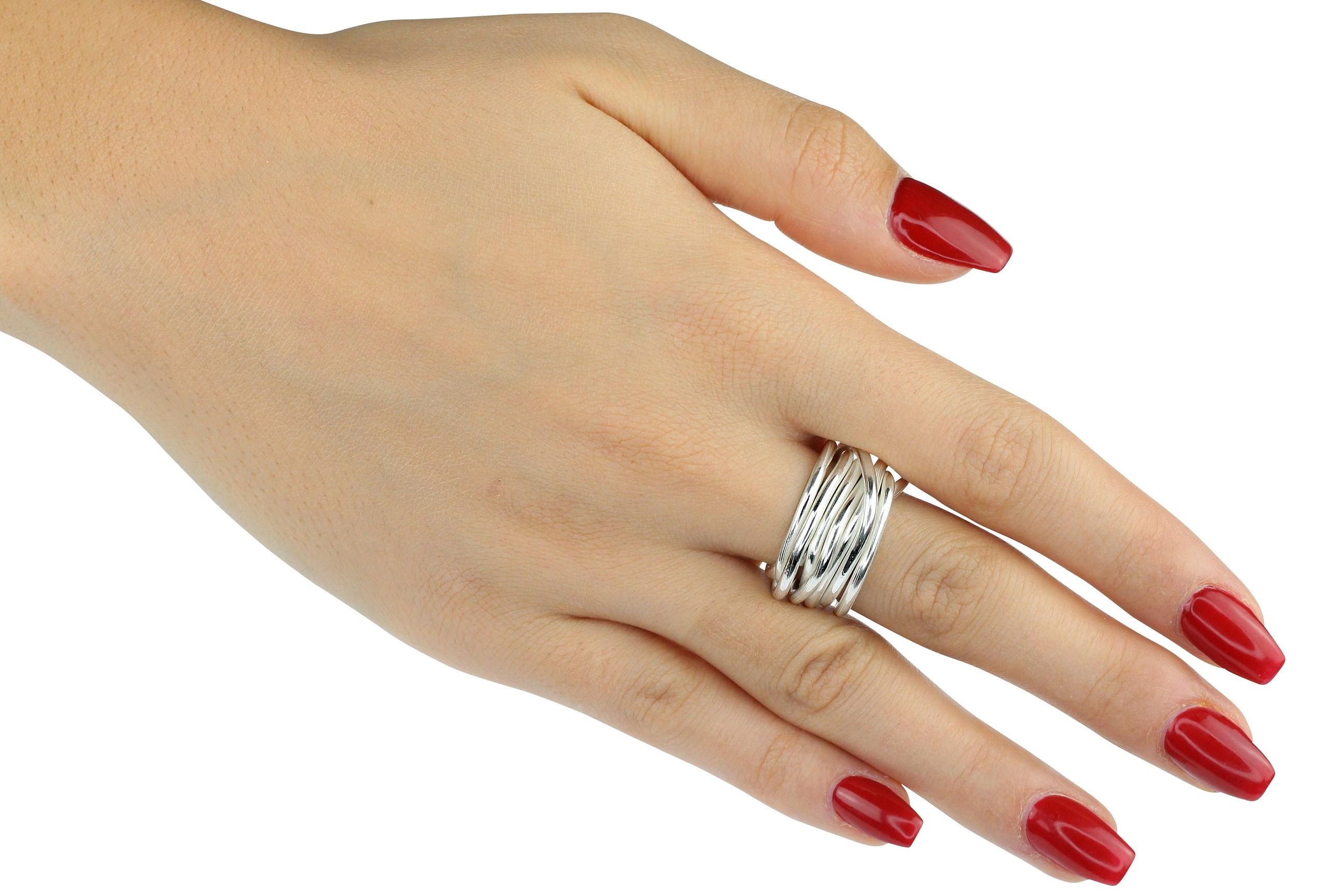 Ein Wickelring aus Silber für Damen bestehend aus sieben einzelnen Silbersträngen, die fest miteinander verbunden sind und dabei zusammen einen Ring formen, getragen an einer Damenhand..