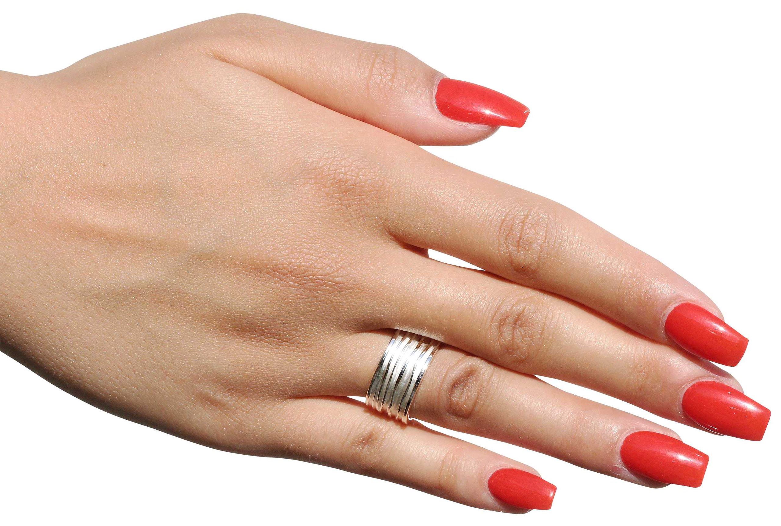 Breiter Silberring mit einer gefalteten Wellenstruktur als Oberfläche getragen an einer Damenhand. Der Ring bietet sich als Schmuck für Damen und für Herren an.