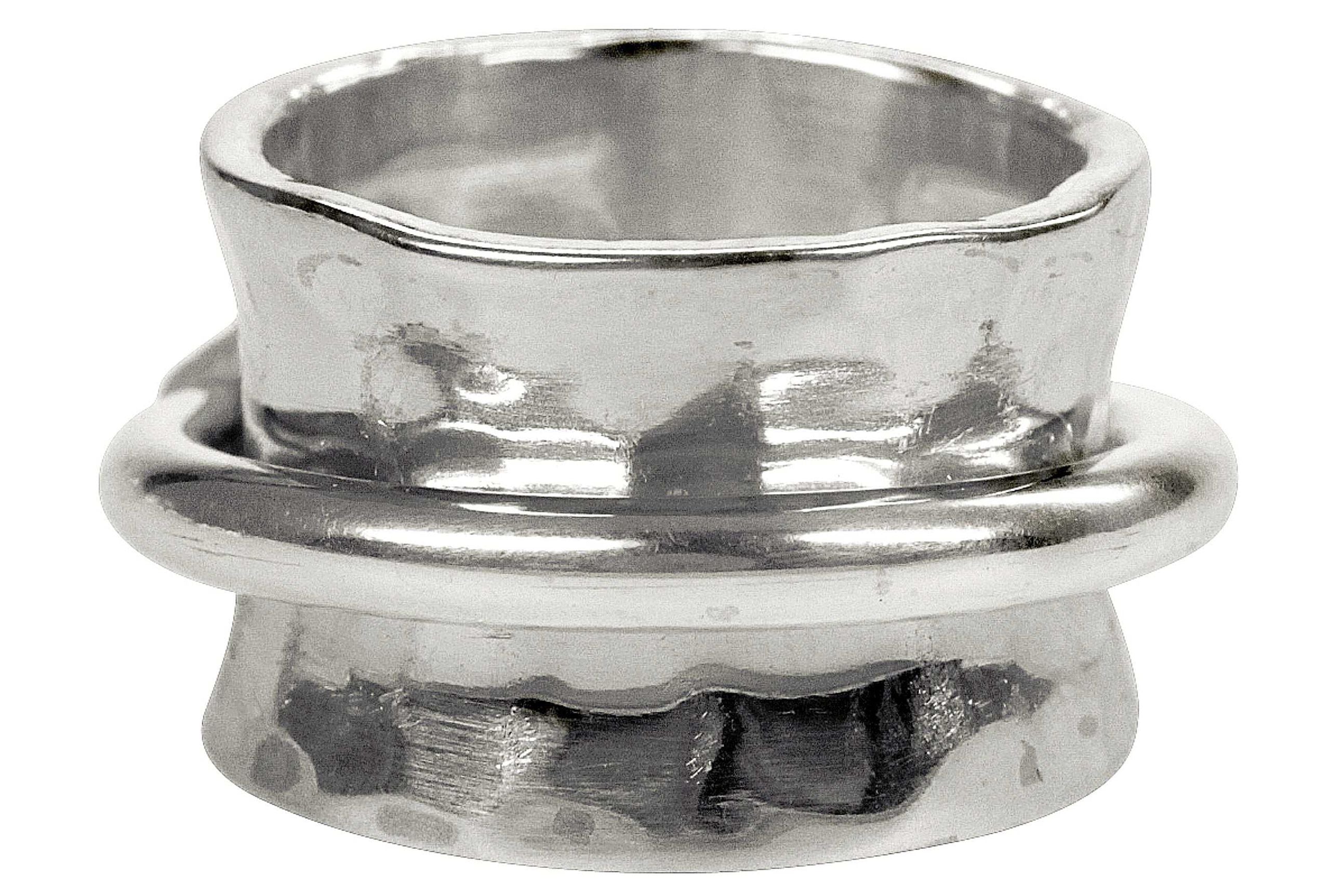 Ein moderner Schmiedering aus Silber bestehend aus einem massivem Bandring und einem kleinen Drehring, der unverlierbar darauf geschmiedet ist.