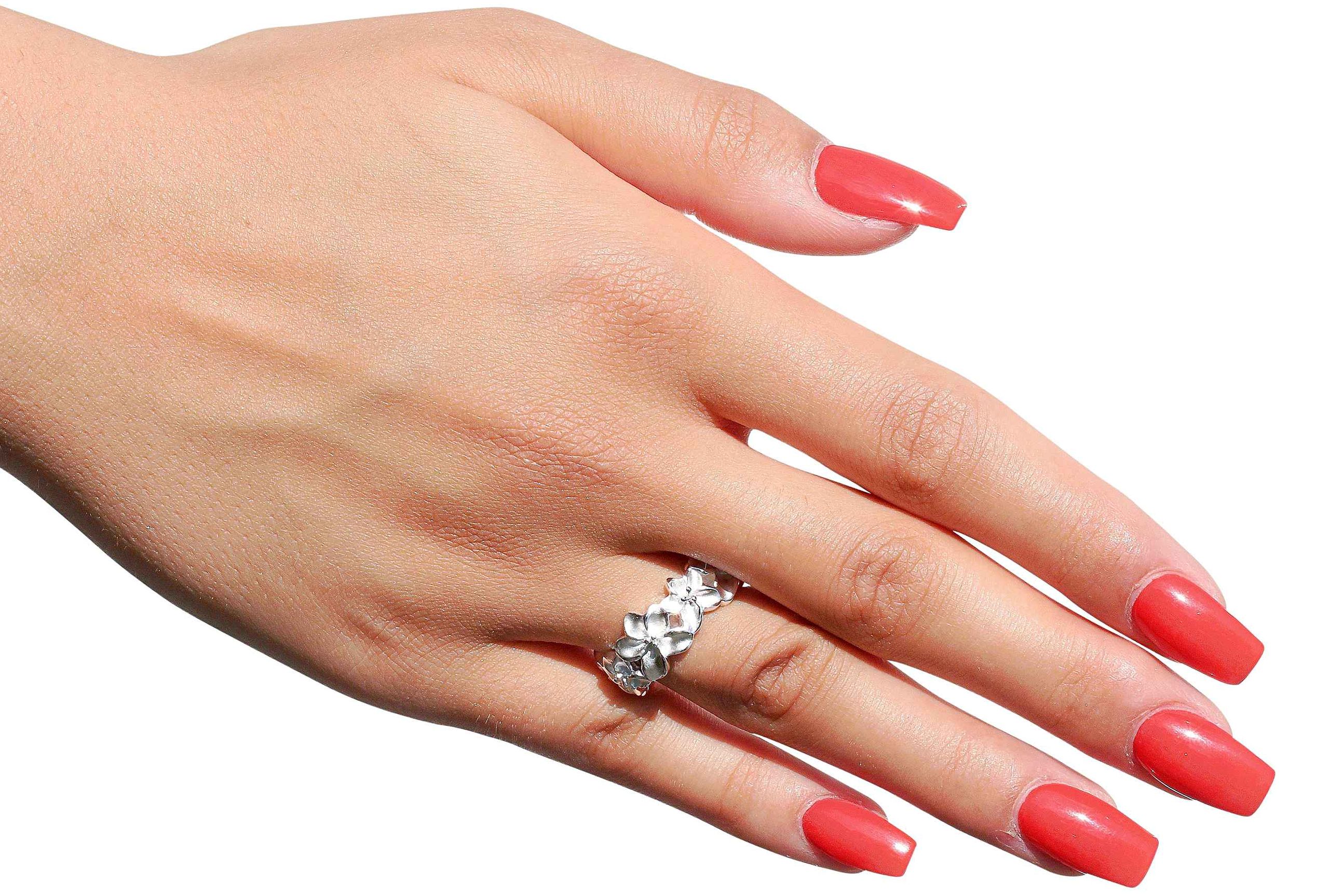 Ring aus Silber im Design eines Blütenrings getragen an einer Damenhand. Der Ring ist massiv gearbeitet und hat eine sandgestrahlte Oberfläche.